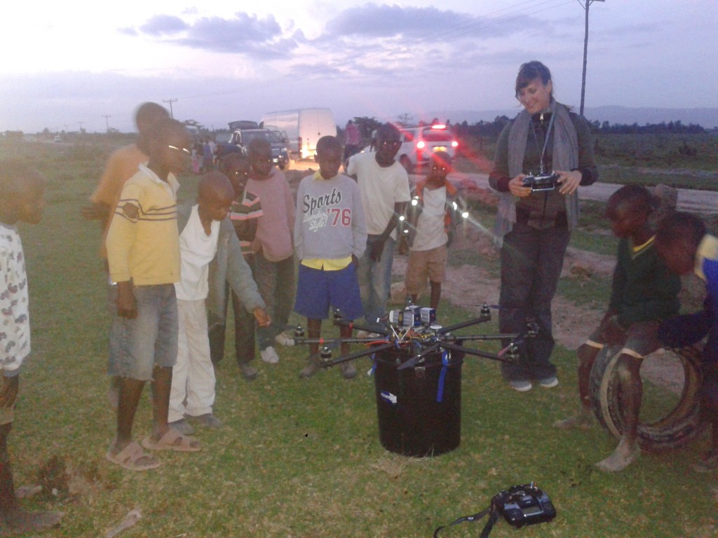 Helivideo camera operater with cinestar octocopter and African kids